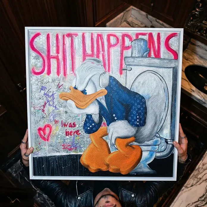 Dotcomcanvas Leinwandbild - Shit happens, B x H: 70 x 70 cm - Gemälde von Donald Duck auf Toilette mit "SHIT HAPPENS"-Graffiti, von Person gehalten.