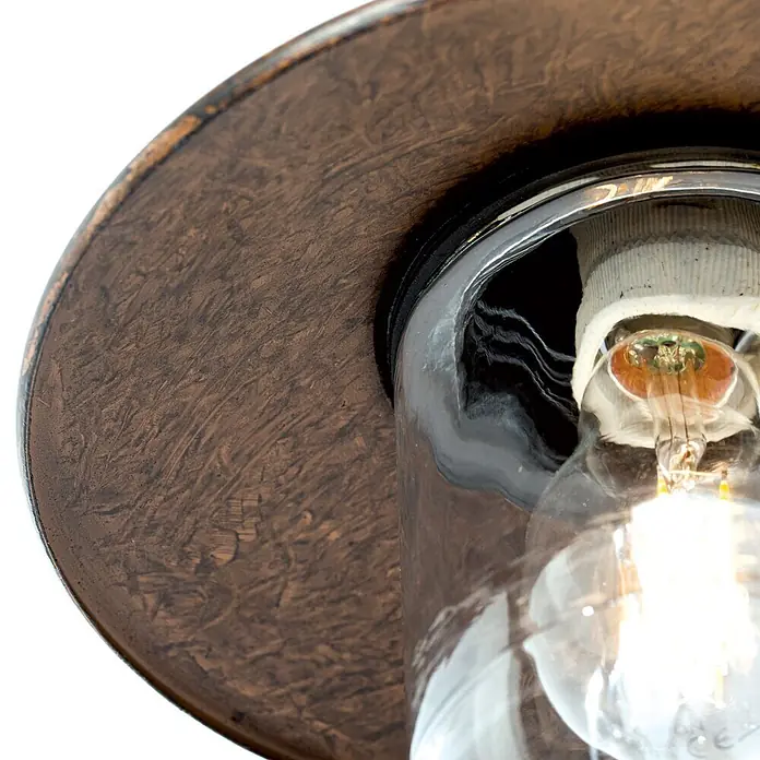 Orion Leuchten Außenwandleuchte Leonie - 60 W, Braun, Klar, IP44 - Nahaufnahme einer rustikalen Außenleuchte aus Bronze mit einer glühenden Glühbirne in einem klaren Glasgehäuse.