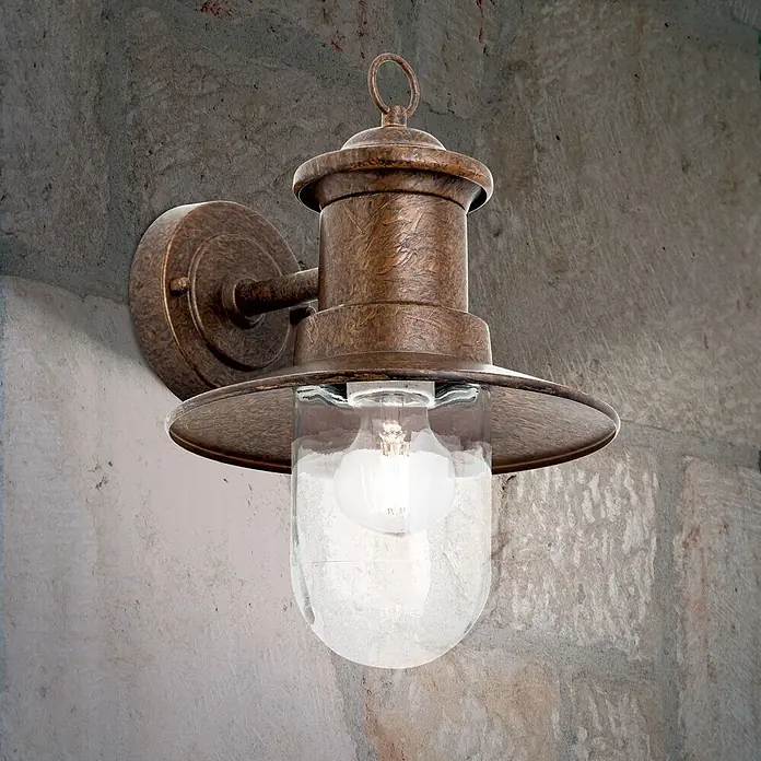Orion Leuchten Außenwandleuchte Leonie - 60 W, Braun, Klar, IP44 - Vintage-Wandleuchte für den Außenbereich aus brünierter Bronze mit klarem Glas, an einer Steinwand montiert.