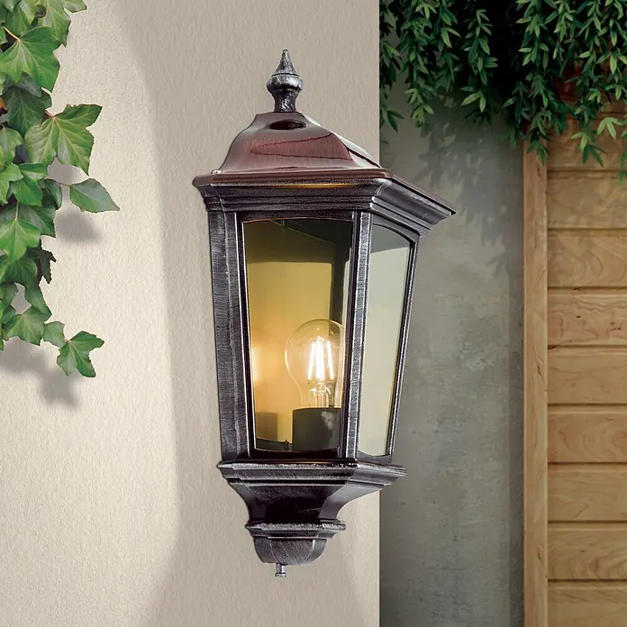 Orion Leuchten Außenwandleuchte Hermine - 60 W, Schwarz, Klar, IP44 - Klassische Außenwandleuchte mit dunklem Metall und rotbraunem Dach, klarem Glas und beleuchteter LED-Birne, an einer Außenwand montiert.