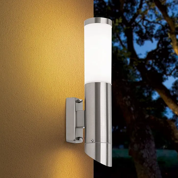Orion Leuchten Außenwandleuchte Pleno - 13 W, Silber, Opal, IP44 - Wandleuchte aus gebürstetem Edelstahl mit zylindrischem Diffusor, beleuchtet eine strukturierte Wand bei Nacht.