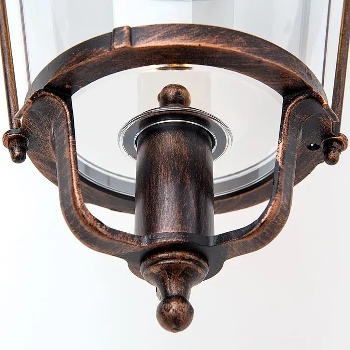 Orion Leuchten Außenwandleuchte Kenzo - 60 W, Schwarz, Klar, IP44 - Nahaufnahme des bronzefarbenen Metallfußes einer Laternenleuchte mit patinierter Oberfläche und Glaseinfassung.