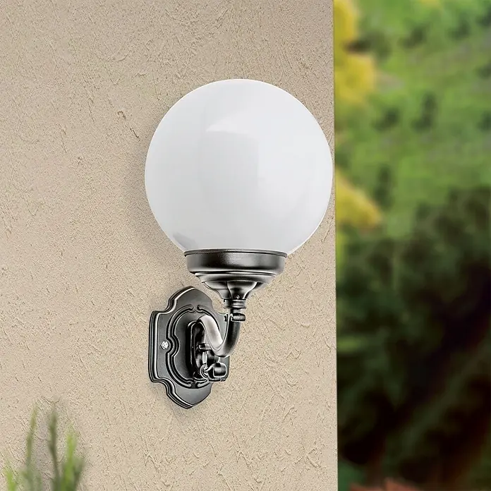 Orion Leuchten Außenwandleuchte Reika - 60 W, Schwarz, Opal, IP43 - Außenwandleuchte mit weißer Kugel und dunklem, verziertem Sockel an einer strukturierten Wand montiert.
