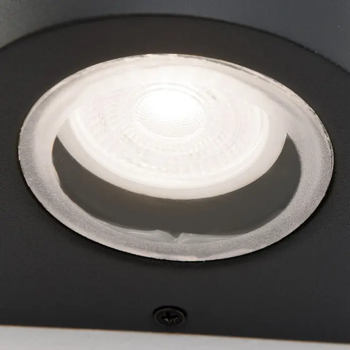 Orion Leuchten Außenwandleuchte Laurenz - 13 W, Anthrazit, Klar, IP54 - Hell leuchtender, eingelassener LED-Spot mit klarem, mattiertem Außenring und strukturierter Innenfläche, in eine dunkle Platte eingesetzt.