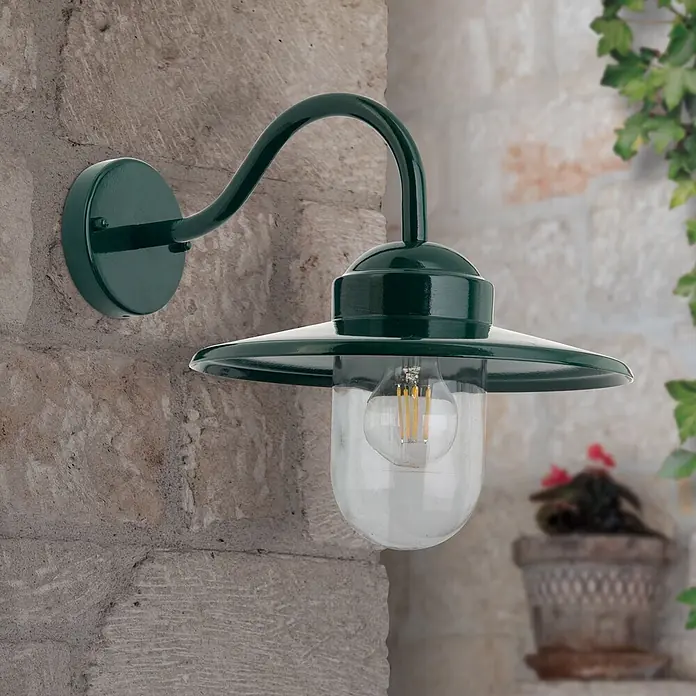 Orion Leuchten Außenwandleuchte Edward - 60 W, Grün, Klar, IP44 - Dunkelgrüne Wandleuchte für den Außenbereich mit geschwungenem Arm, konischem Schirm und klarer Glaskugel mit LED-Birne an Steinwand.