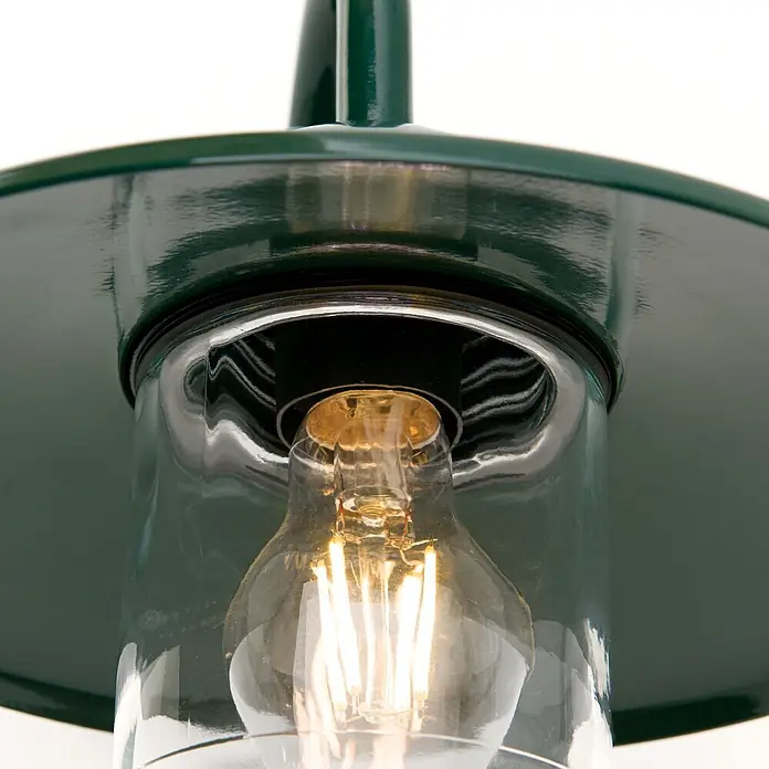 Orion Leuchten Außenwandleuchte Edward - 60 W, Grün, Klar, IP44 - Nahaufnahme einer dunkelgrünen Metall-Außenlaterne mit klarem Glasschirm, die eine Edison-LED-Glühbirne beleuchtet.