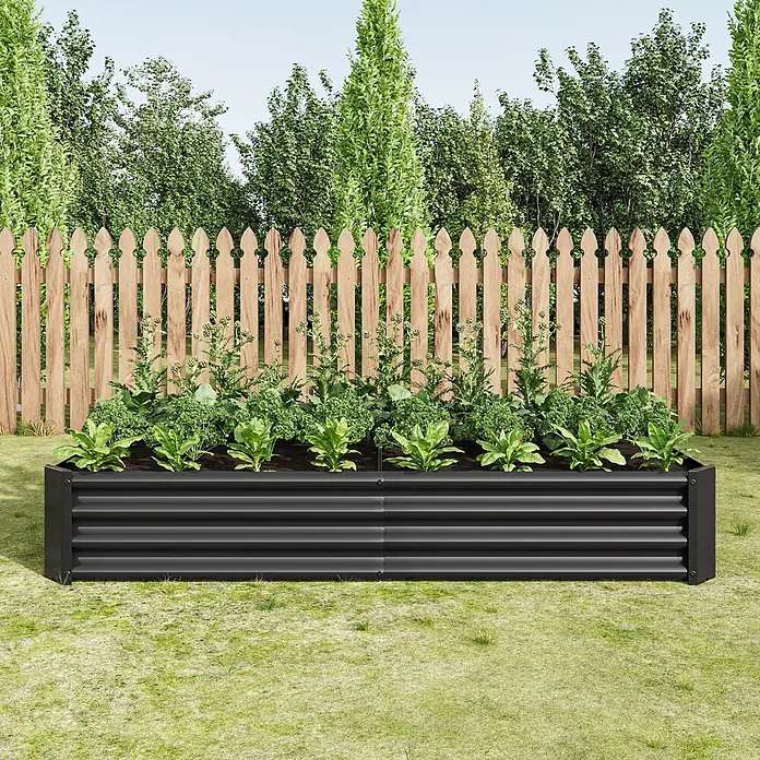SONNENH Hochbeet bodenlos - Stahl, anthrazit - Schwarzes Hochbeet aus Metall mit verschiedenen grünen Pflanzen, in einem grünen Garten mit Holzzaun und Bäumen.