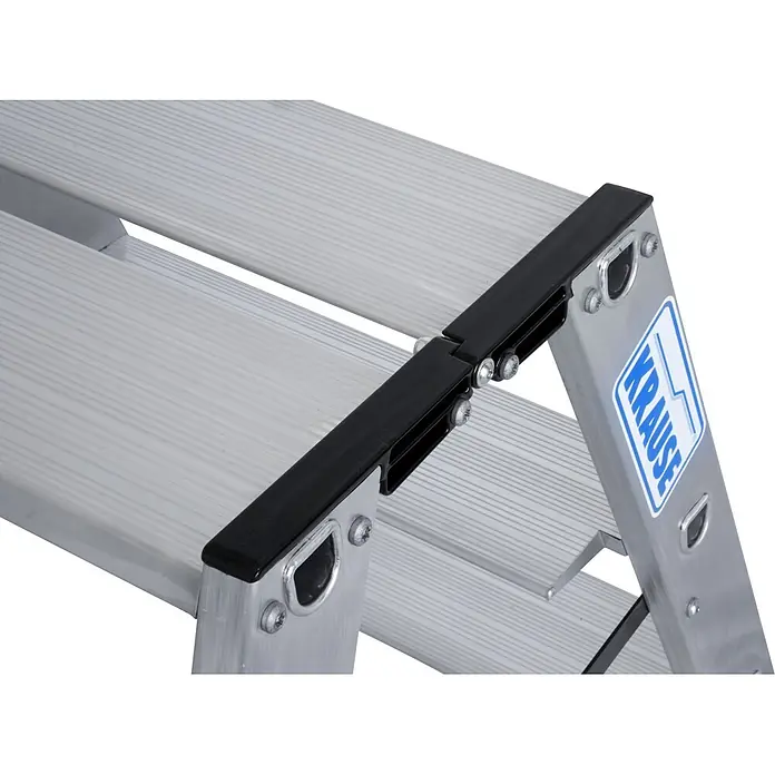 Krause Doppel-Klapptritt 2X4 Stufen - Anzahl Tritte: 8 Stk., Belastbarkeit: 225 kg, Aluminium - Nahaufnahme einer silbernen Aluminium-Klappleiter mit geriffelten Stufen und einem schwarzen Scharnier. Blaues KRAUSE-Logo.