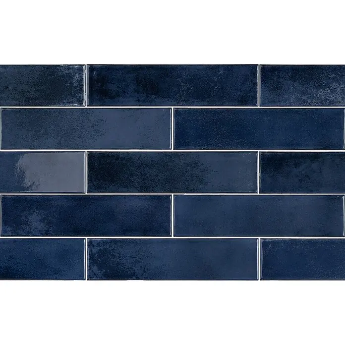 Wandfliese Santorini - 7,5 x 30 cm, Dark Blue, Glänzend - Nahaufnahme von glänzenden, blauen, rechteckigen Metrofliesen mit variabler Textur und weißer Fuge.