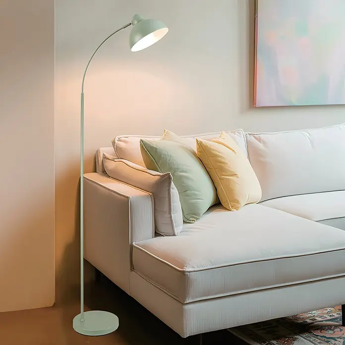 Alemar Lámpara de pie LED Niu - 60 W, Altura: 155 cm, Verde - Lámpara de pie arqueada verde menta junto a un sofá blanco, proporcionando luz cálida.