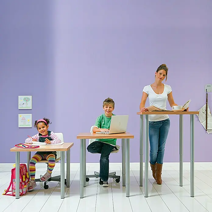 Element System Pata telescópica para muebles Expand - Diámetro: 5 cm, Ajuste de altura: 80 cm - 120 cm, Capacidad de carga: 75 kg, Acero, Aluminio - Niños y una mujer sentados en escritorios de altura regulable, adaptándose a diferentes grupos de edad.