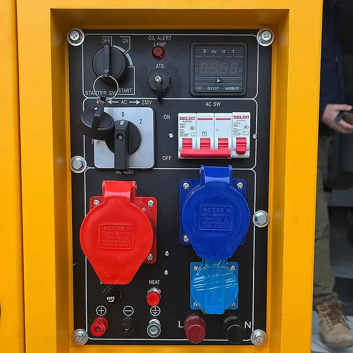 KIPOR Stromerzeuger Diesel AVR Stromerzeuger 16 kW / 20 kVA - KIPOR DG20000 - Nennleistung: 16 kW, Tankvolumen: 30 l - Gelbes Generator-Bedienfeld mit schwarzer Steuerplatine, Schaltern, roten und blauen Industriesteckdosen, Leistungsschaltern und Digitalanzeige.
