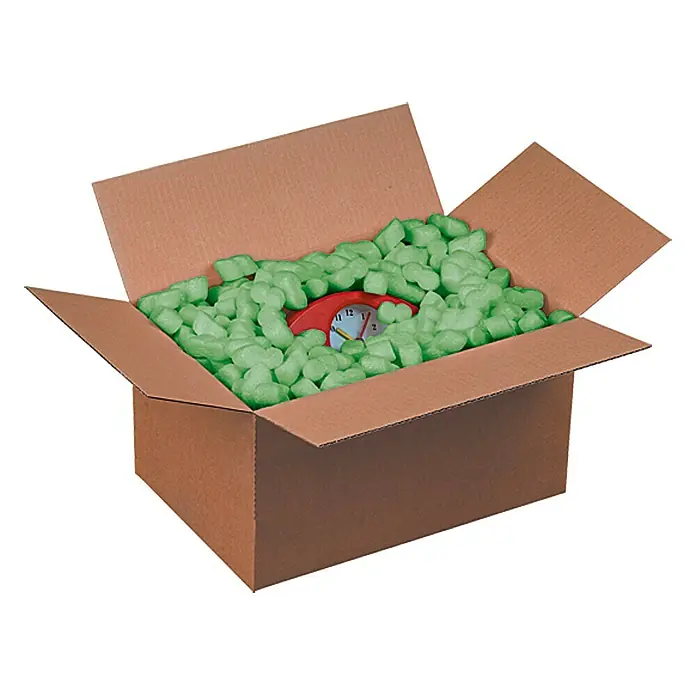 Füllmaterial für Haustierkäfige Soft-Fill - 90 l - Eine offene Pappschachtel gefüllt mit grünen Verpackungschips und einer roten Uhr, die zum sicheren Transport von Artikeln verwendet wird.