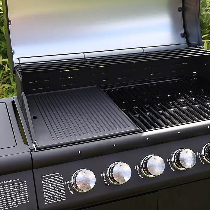 TAINO Grillplatte - L x B: 31 x 42 cm, Gusseisen - Nahaufnahme eines geöffneten schwarzen Gasgrills mit gerippter Gussplatte, Rosten und Chrom-Bedienknöpfen.