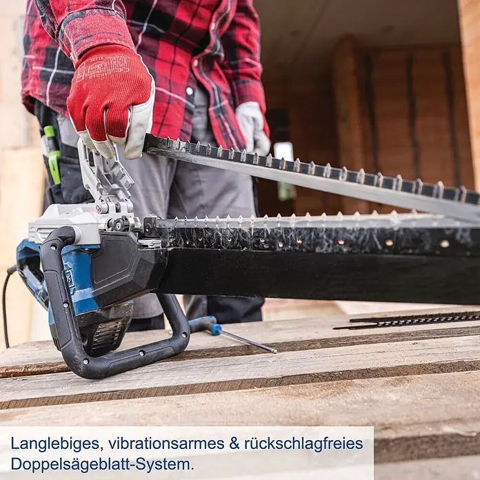 Scheppach Universalsäge AZE430 - 1.500 W, L x B x H: 970 x 220 x 125 mm - Person mit Handschuhen handhabt eine blaue und schwarze Doppelsäge mit gezackten Blättern, ihr Doppelsägeblatt-System offenbarend.