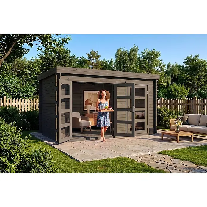 Alpholz Gartenhaus ECO Set Paloma Grande grau 28mm Wandstärke - Außenmaß inkl. Dachüberstand (B x T): 398 x 230 cm, Holz, Grau - Dunkelgraues, modernes Gartenhaus, aus dem eine Frau mit einem Tablett mit Getränken und Obst tritt, auf einer Terrasse mit Gartenmöbeln.