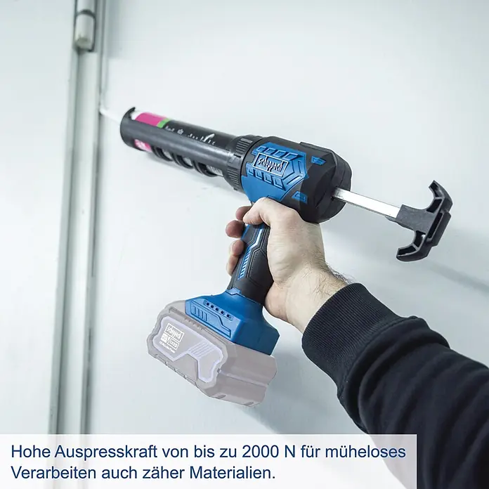 Scheppach IXES 20V Akku-Kartuschenpresse C-SEG310-X - 20 V, Ohne Akku - Eine Person verwendet eine blau-schwarze Scheppach Akku-Kartuschenpistole mit grauem Akku, um Dichtmasse an einer weißen Wand aufzutragen.