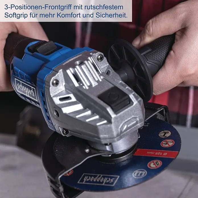 Scheppach IXES 20V Akku-Winkelschleifer BC-AG125P-X - 20 V, Ohne Akku, 7.000 U/min - 10.000 U/min - Blauer Winkelschleifer mit silbernem Gehäuse und 3-Positionen-Frontgriff wird von Händen gehalten, mit eingesetzter 125mm Trennscheibe.