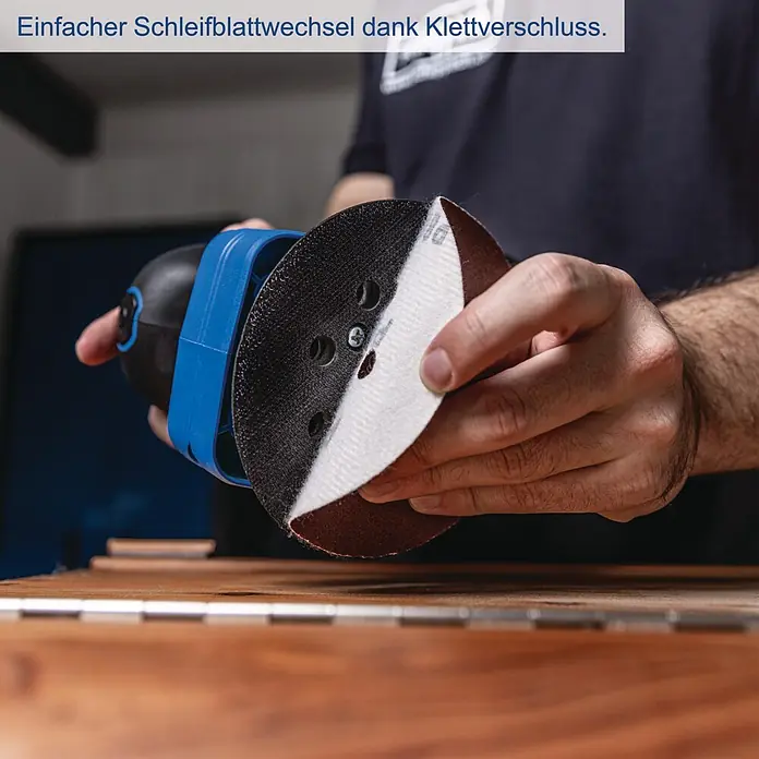 Scheppach IXES 20V Akku-Multischleifer C-MSA3/1-X - 20 V, Ohne Akku, Leerlaufschwingzahl: 14.000 U/min - 24.000 U/min - Hand wechselt Schleifblatt mit Klettverschluss an schwarzem und blauem Exzenterschleifer.