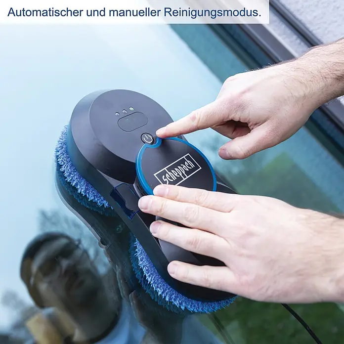 Scheppach Fensterreinigungsroboter WCR72 - Wassertankvolumen Roboter: 35 ml, Saugkraft: 2.800 Pa - Hände bedienen einen schwarz-blauen Scheppach Fensterputzroboter auf Glas, der automatische und manuelle Reinigungsmodi zeigt.