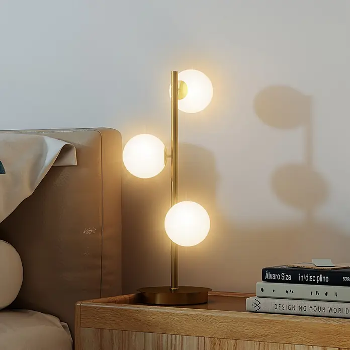 Homcom Tischleuchte - 25 W, L x B x H: 24 x 24 x 53 cm, Gold, Weiß, G9 - Goldene Tischlampe mit drei weißen Kugelleuchten auf einem Nachttisch aus Holz.