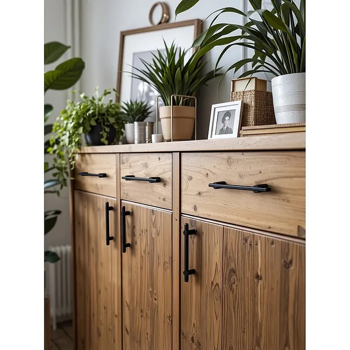 Nesu Tirador para muebles - Distancia entre orificios: 96 mm, Negro, 4 ud. - Gabinete de madera con veta natural y tiradores negros, decorado con plantas en maceta y elementos decorativos.