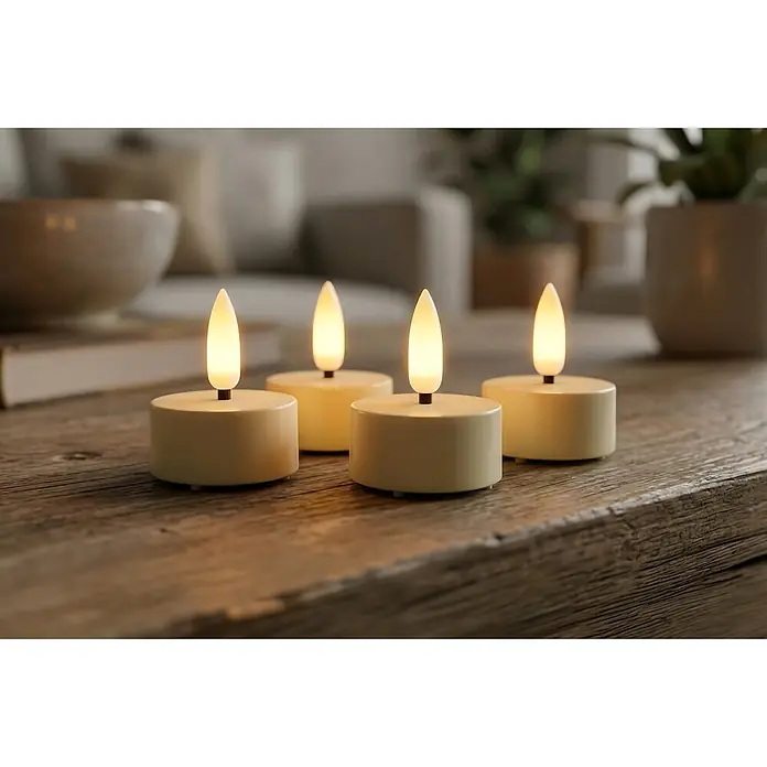 LED-Teelicht 3D Lucina - 4 Stk., Creme - Vier cremefarbene LED-Teelichter mit flackernden Flammen auf einem Holztisch, schaffen gemütliche Atmosphäre.