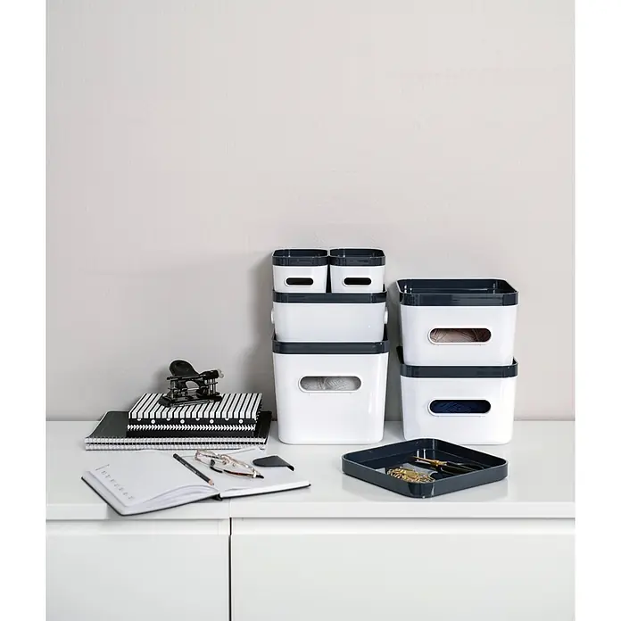 SmartStore Vorratsdose Compact - L x B x H: 20 x 20 x 12 cm, Kunststoff, Weiß - Gestapelte weiße Aufbewahrungsboxen mit dunkelgrauen Rändern und passendem Tablett auf einem Schreibtisch mit Bürobedarf.