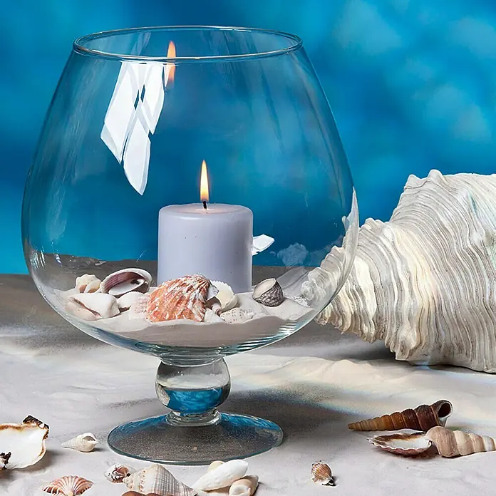 Dekosand -  - Dekoratives Windlicht mit Kerze, Sand und Muscheln in einem Glasgefäß, perfekt für eine maritime Atmosphäre.
