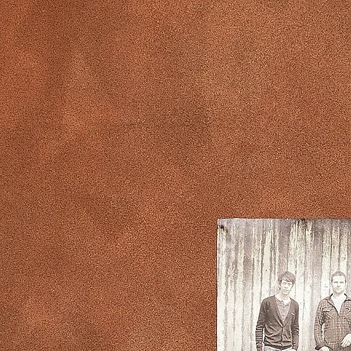 SCHÖNER WOHNEN-Farbe Trendstruktur Dekoputz-Set Rost-Optik - 6 -tlg. - Zwei Männer stehen vor einer verwitterten Wand, eingefangen in einem nostalgischen Schwarzweiß-Foto, das eine rostige Textur überlagert.