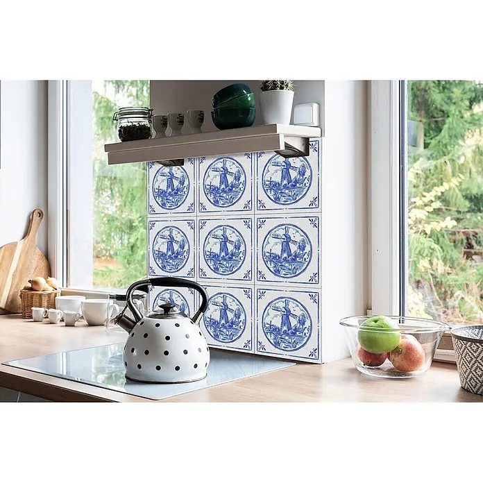 Tulup Wandfliese - Glänzend - Blau-weiß gemusterter Küchenrückwand mit Windmühlenmotiven, über einem Kochfeld in einer hellen Küche.