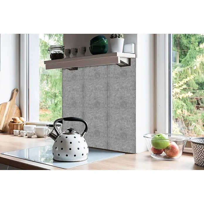 Tulup Wandfliese - Glänzend - Graue selbstklebende Fliesen in Betonoptik als Küchenrückwand unter einem Regal, mit einem Wasserkocher auf der Arbeitsplatte.