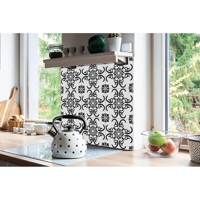 Tulup Wandfliese - Glänzend - Dekorative schwarz-grau gemusterte Küchenfliesen als Spritzschutz neben einem Fenster in einer hellen Küche.