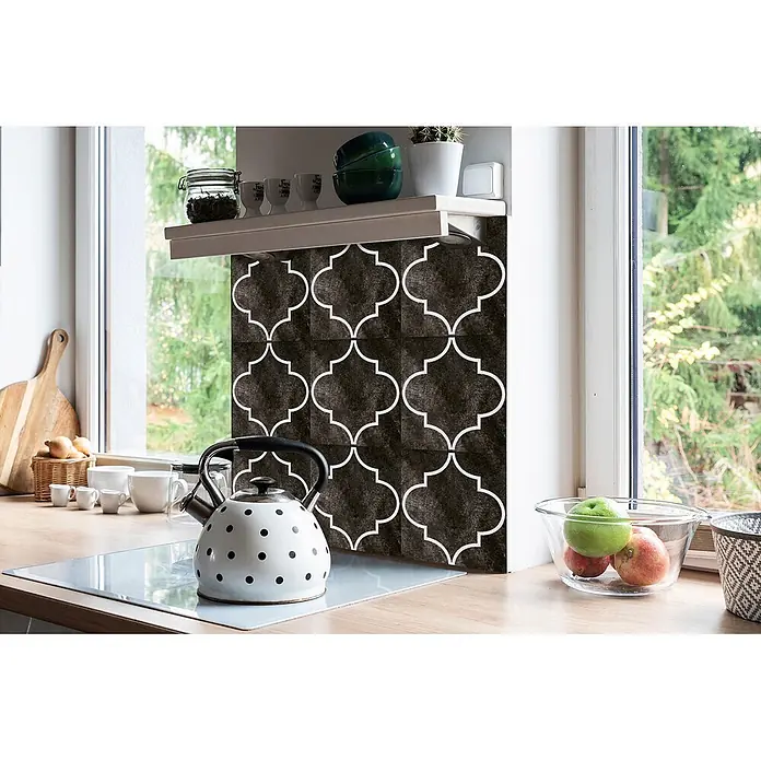 Tulup Wandfliese - Glänzend - Schwarze Küchenrückwandfliesen mit weißem Quatrefoil-Muster, als Spritzschutz über einer Arbeitsplatte.