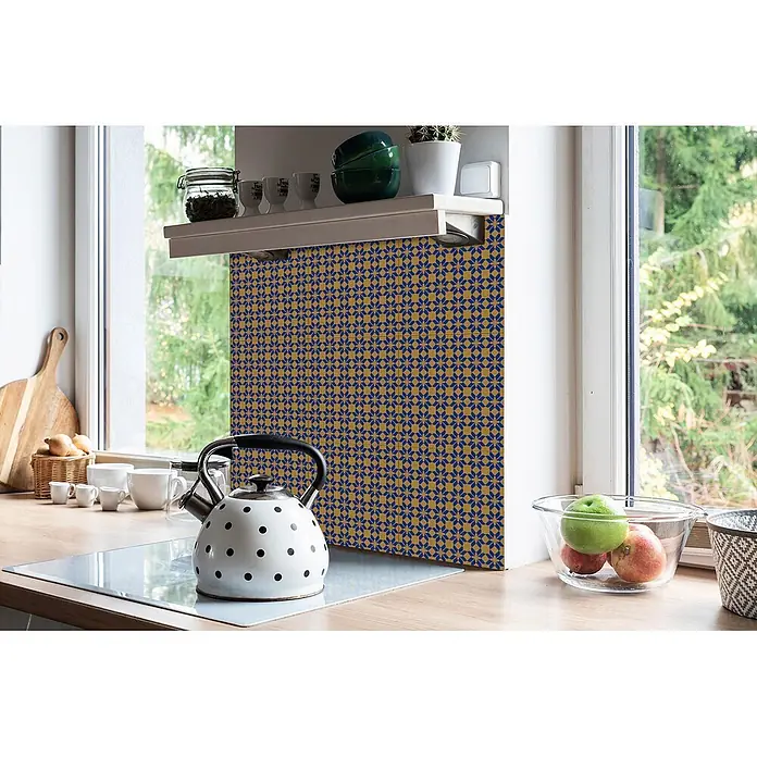Tulup Wandfliese - Glänzend - Geometrische blau-gold gemusterte Rückwandfliesen in einer Küche, hinter einem Wasserkocher und unter einem Regal.