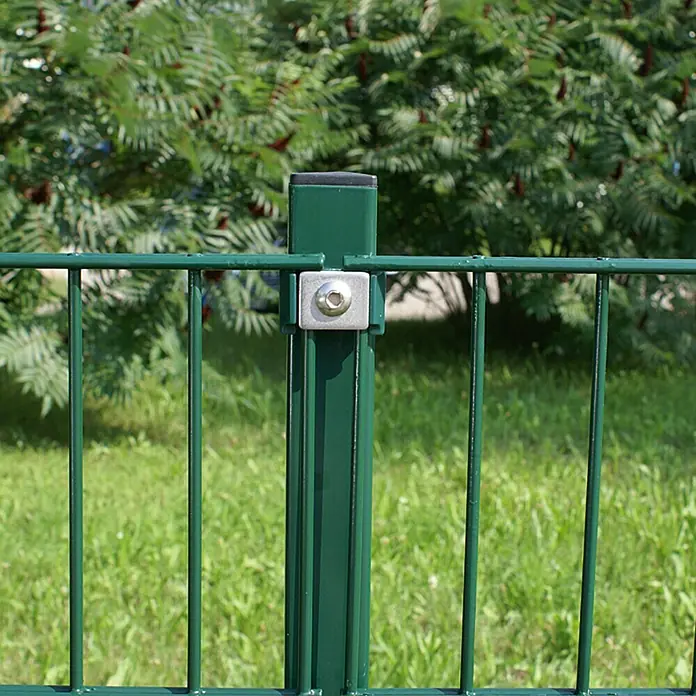 Hadra Mattenzaun SMALL - L x H: 2 x 1,03 m, Grün - Nahaufnahme eines grünen Maschendrahtzauns mit Metallpfosten und Befestigungselementen vor üppigem Grün.