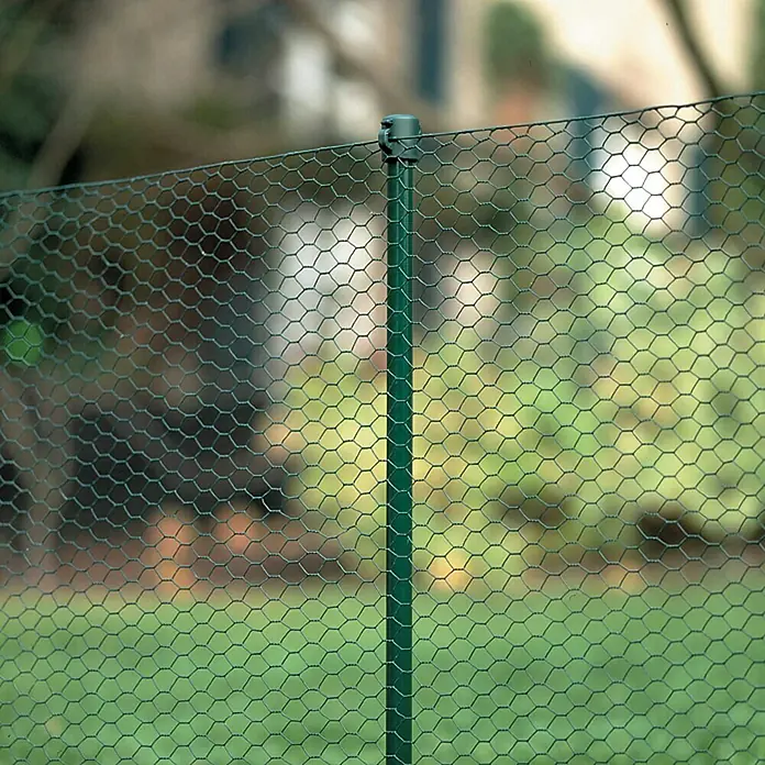 Stabilit Zaunpfosten - Durchmesser: 18 mm, Grün, Metall - Nahaufnahme eines grünen Maschendrahtzauns im Garten, der durch einen stabilen Metallpfosten gestützt wird und Schutz bietet.
