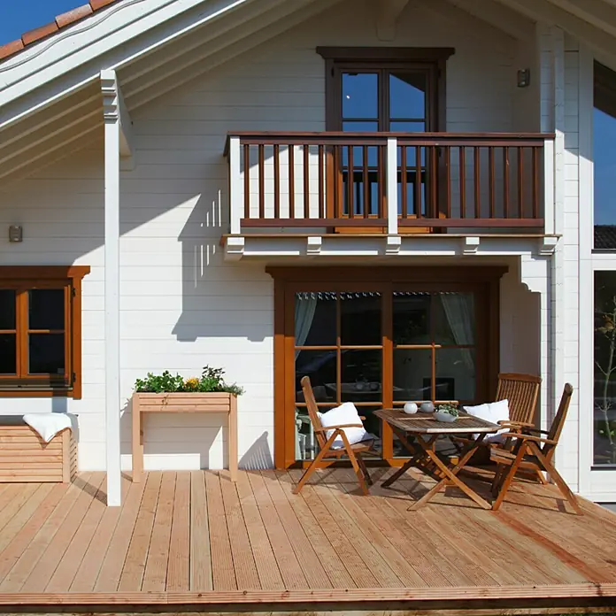 Terrassendiele - Douglasie, 400 x 14,5 x 2,8 cm, Rötlich gelblich - Blick auf ein modernes Holzhaus mit Terrasse, Gartenmöbeln und Holzbalkon. Das helle Holzdesign verleiht dem Haus eine freundliche Atmosphäre.