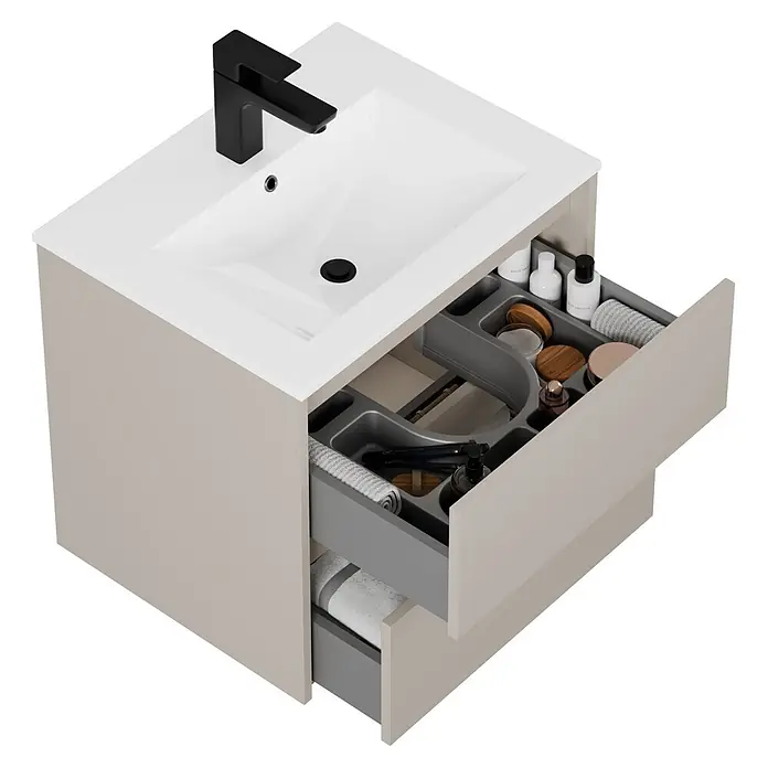 Riva Sabbia Badmöbel-Set - Gesamtbreite Badmöbel: 61,5 cm, Kaschmir, Matt - Beige Waschtischunterschrank mit weißem Waschbecken, schwarzem Wasserhahn und geöffneten Schubladen mit organisierten Toilettenartikeln und Handtüchern.