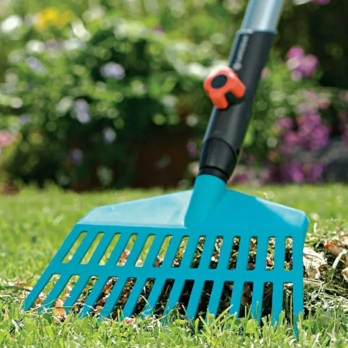 Gardena Combisystem Rechenbesen - Arbeitsbreite: 27 cm, Kunststoff - Nahaufnahme eines blauen Gartenrechens auf Rasen, ideal zum Laubsammeln und zur Gartenpflege.