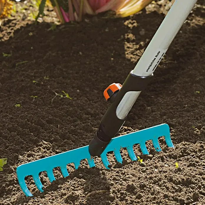 Gardena Combisystem Gartenrechen - Arbeitsbreite: 30 cm, Stahl, Anzahl Zinken: 12 Stk. - Nahaufnahme eines blauen Gartenrechens, der im Erdreich verwendet wird, um den Boden zu ebnen.