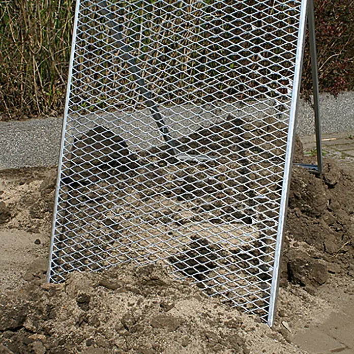 Durchwurfsieb - 100 x 60 cm - Gartensieb zur Bodensortierung. Das Metallsieb ist in einem Erdhaufen platziert, um Steine und grobe Bestandteile zu trennen.
