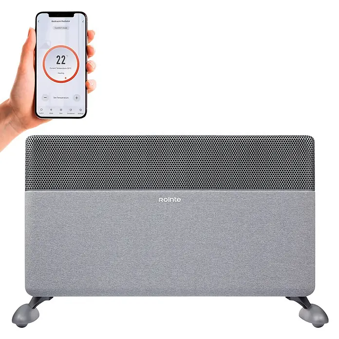 Rointe Convector Iroko - 2.000 W, 12 x 80 x 42 cm, Gris - Radiador inteligente Rointe gris con parte superior perforada, mostrado con una mano sosteniendo un smartphone con su app de control.