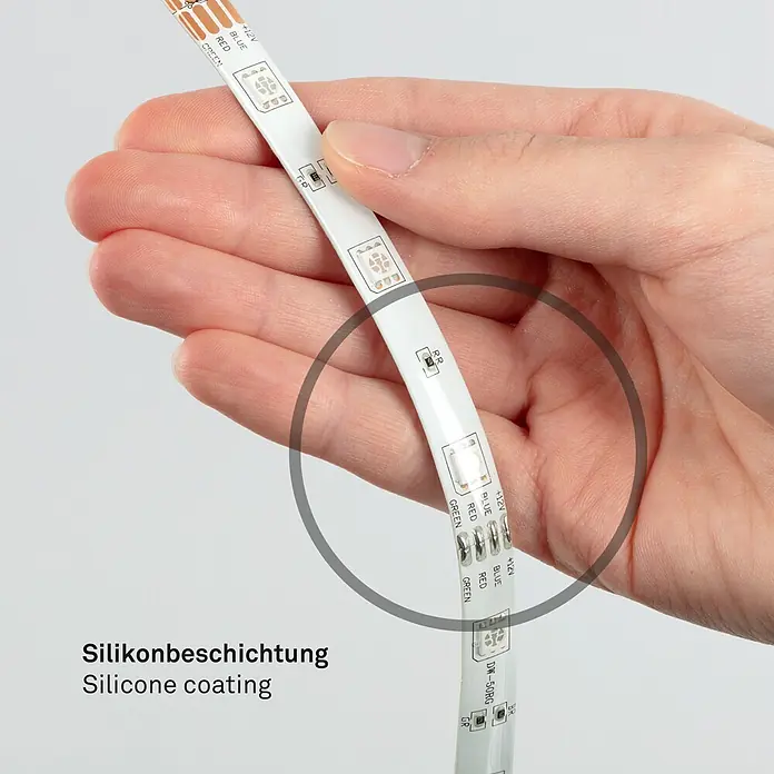 Briloner LED-Band Flexband - Länge: 5 m, Lichtfarbe: RGBW, 22 W - Flexibler LED-Streifen mit Silikonbeschichtung, in einer Hand gehalten zur Demonstration der Schutzschicht.