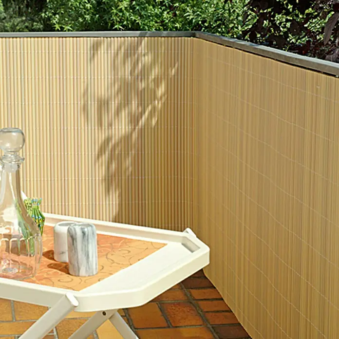 Gardol Comfort Sichtschutzmatte - Bambus Optik, 300 x 90 cm - Der Balkon ist mit einem Sichtschutz aus Bambusmatten verkleidet, der Privatsphäre bietet. Auf einem Tisch stehen Dekorationen.