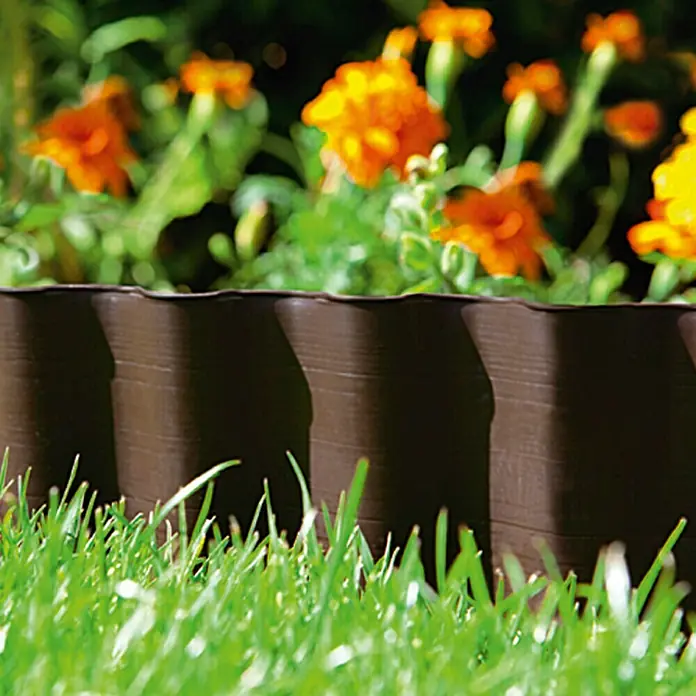 Gardena Beeteinfassung - 9 m x 20 cm, Schwarz - Braune Rasenkante aus Kunststoff mit Holzstruktur, die einen Blumenbereich von einem Rasen trennt, wodurch ein sauberes und gepflegtes Aussehen entsteht.