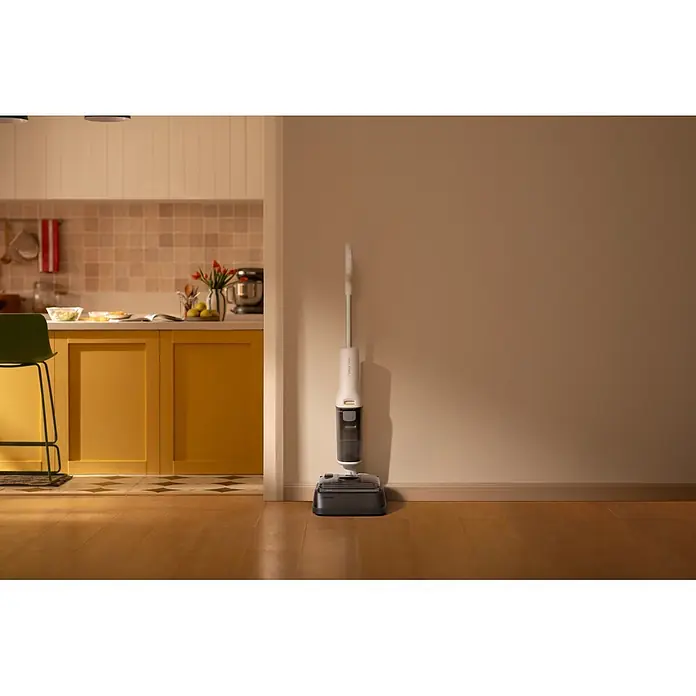 Roborock Akku-Nass-Trockensauger F25 RT Gen 2 - Saugkraft: 20.000 Pa, Akkulaufzeit: 22 min - 38 min, Wassertankvolumen: 870 ml - Weißer und dunkelgrauer Roborock Nass-/Trockensauger auf Ladestation, im Hintergrund eine Küche.