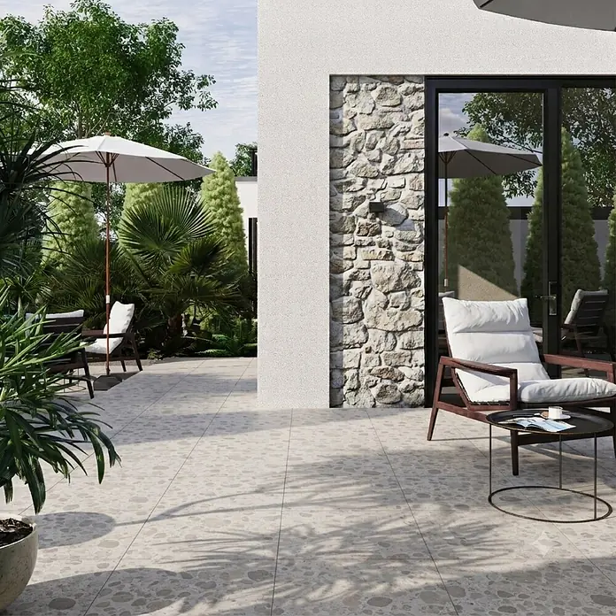 Feinsteinzeugfliese Vogue - 60 x 60 cm, Sand, Matt - Helle Outdoor-Terrassenfliesen mit unregelmäßigem, kieselartigem Muster, verwendet in einer modernen Terrassenumgebung mit Gartenmöbeln.