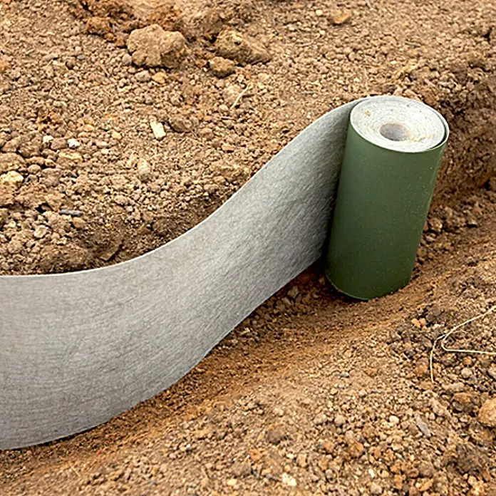 Gardol Premium Wurzelsperre - Polypropylen, 10 x 0,2 m - Nahaufnahme einer Rolle Unkrautvlies auf braunem Boden. Das Vlies dient der Unkrautbekämpfung im Garten.