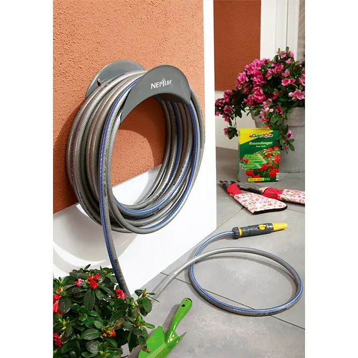 Neptun Wand-Schlauchhalterung - Geeignet für: 30 m Schlauch 12,7 mm (½″) - Eine Nahaufnahme eines Neptun-Gartenschlauchs, ordentlich auf einer grauen Halterung aufgerollt, mit einem Teil auf dem Boden.
